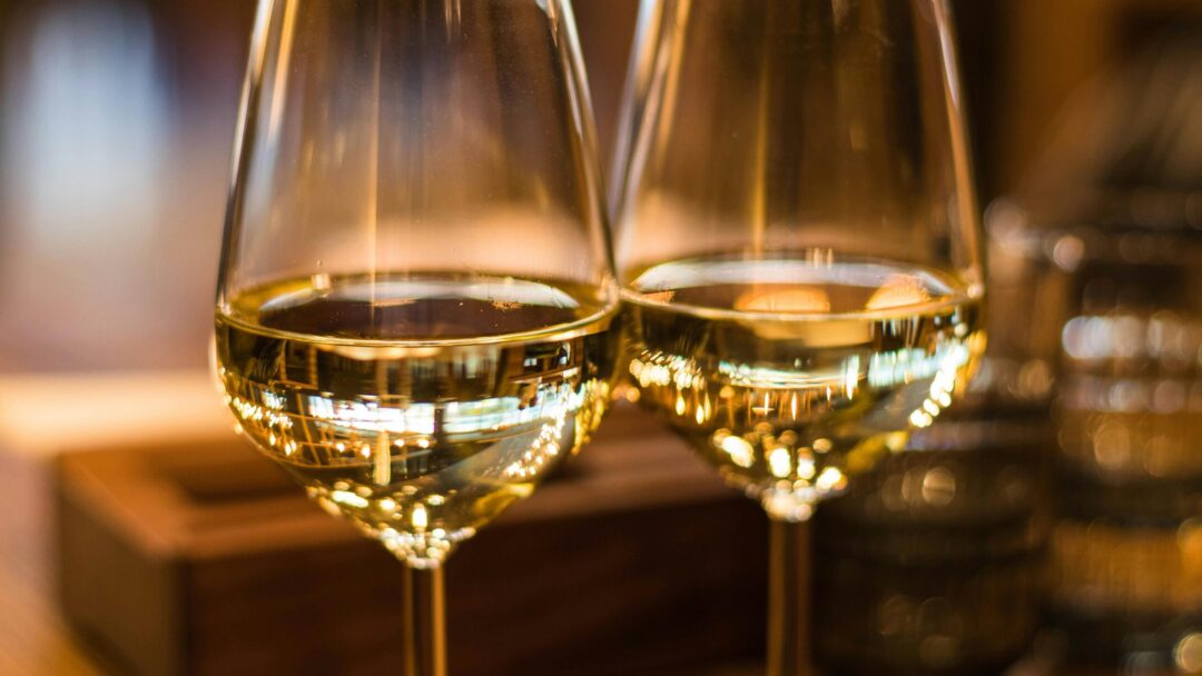 pexels-photo-1123260-1123260 Two elegant wine glasses filled with white wine, captured with a beautiful bokeh effect.