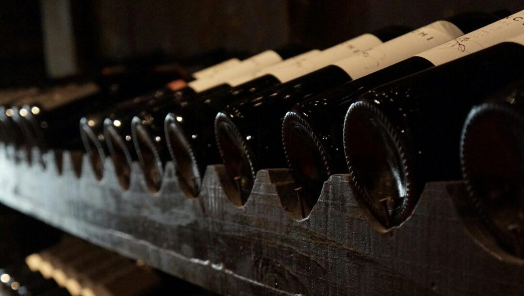 pexels-photo-774455-774455 A dimly lit wine cellar showcasing rows of wine bottles on rustic wooden shelves, creating a classic and elegant atmosphere.